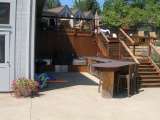 Result of a landscape desgn featuring an outdoor patio and kitchen area below a wooden deck.